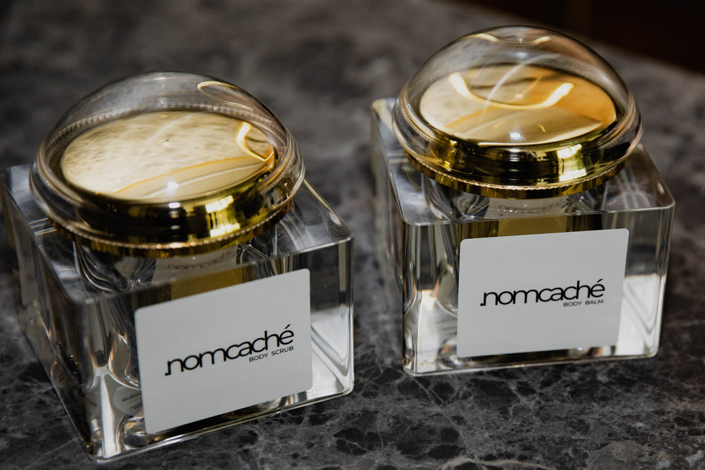 Otwarty peeling i balsam do ciała .nomcaché na marmurowym blacie — .nomcaché body scrub and balm open on marble surface