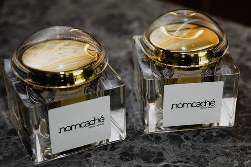 Otwarty peeling i balsam do ciała .nomcaché na marmurowym blacie — .nomcaché body scrub and balm open on marble surface